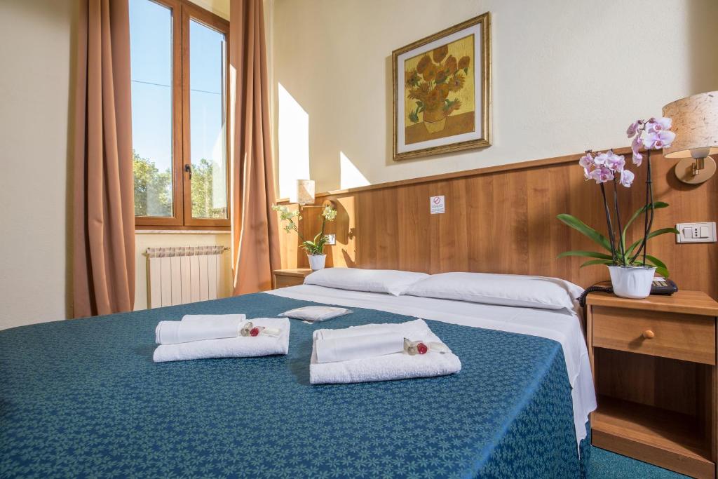 una camera da letto con un letto blu e asciugamani di Hotel Trastevere a Roma
