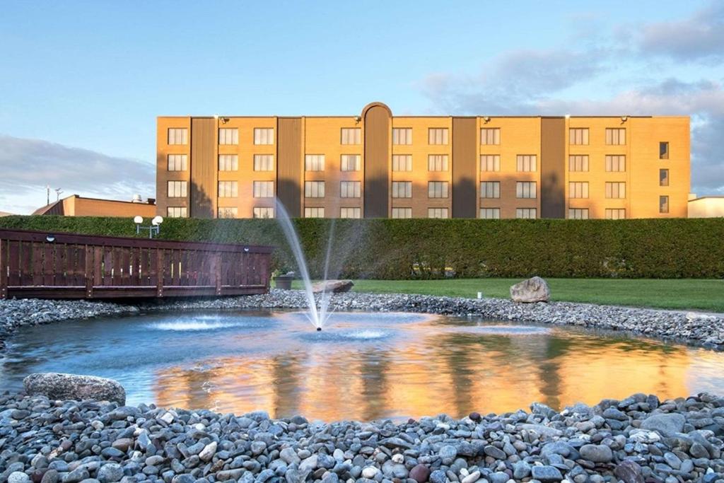 a fountain in a pond in front of a building at Hotel Le Victorin, Ascend Hotel Collection in Victoriaville