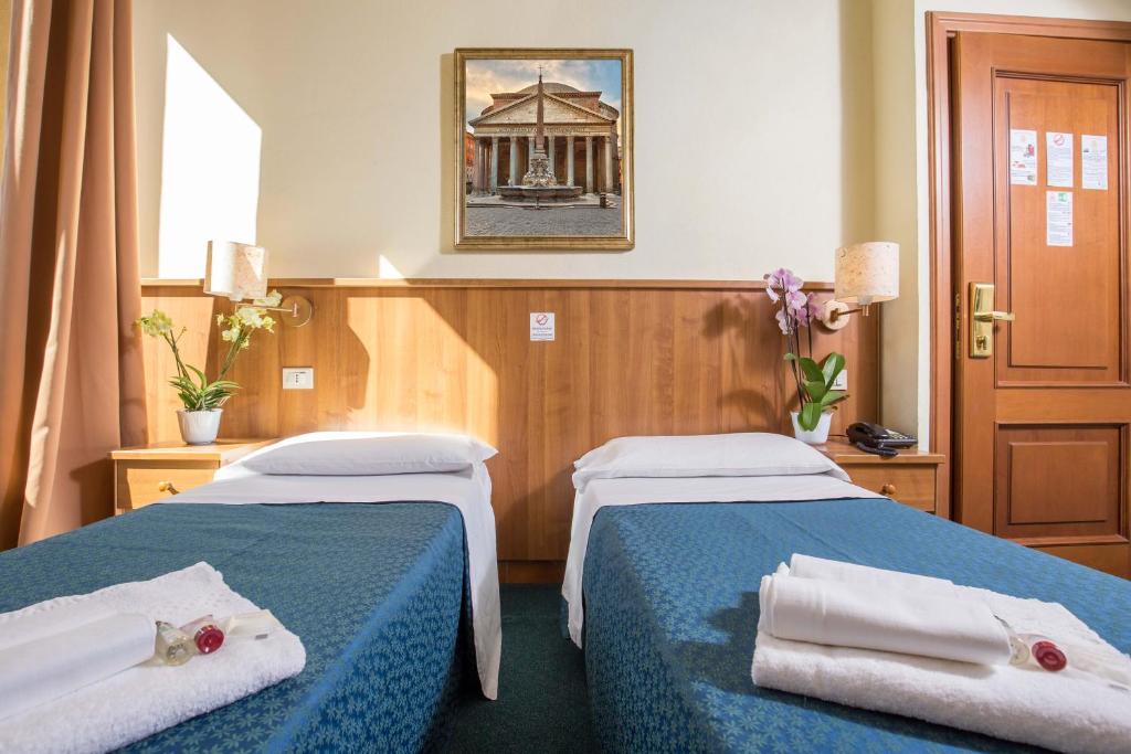 a hotel room with two beds with towels on them at Hotel Trastevere in Rome