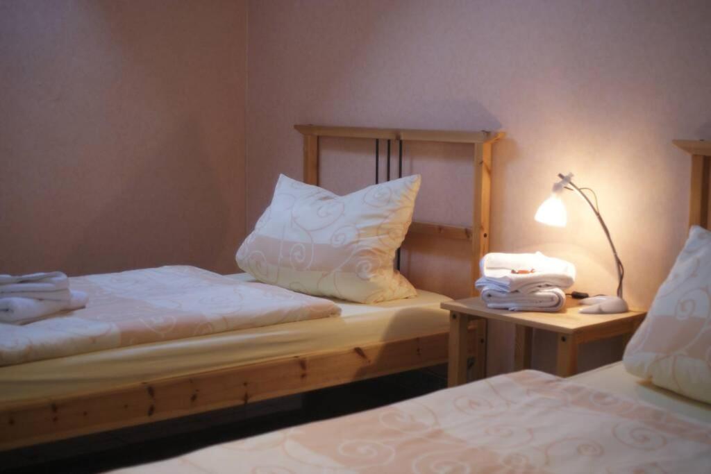 a bedroom with two beds and a lamp on a table at Ferienwohnung Wille in Lünen