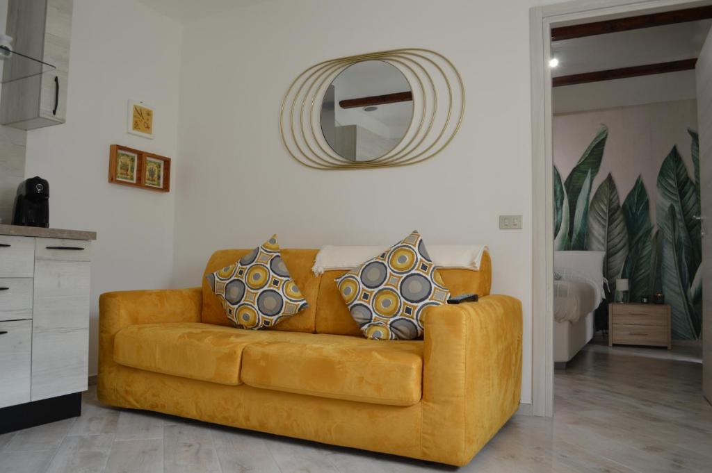 ein braunes Sofa im Wohnzimmer mit Spiegel in der Unterkunft Dalle Sorelle in Moncalvo