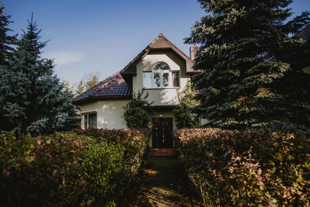 ein weißes Haus mit einem Zaun und Bäumen in der Unterkunft RUDAWSKI in Janowice Wielkie