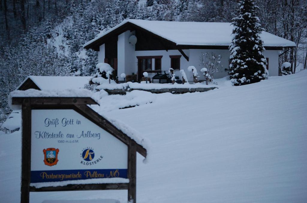 un cartel en la nieve frente a un edificio en Haus Kinsperger, en Klösterle am Arlberg