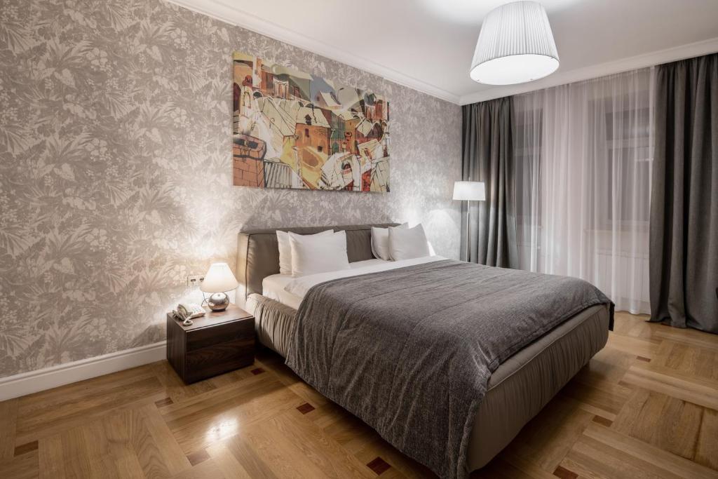 una camera da letto con un letto e un dipinto sul muro di Cityhotel Apartments a Kiev