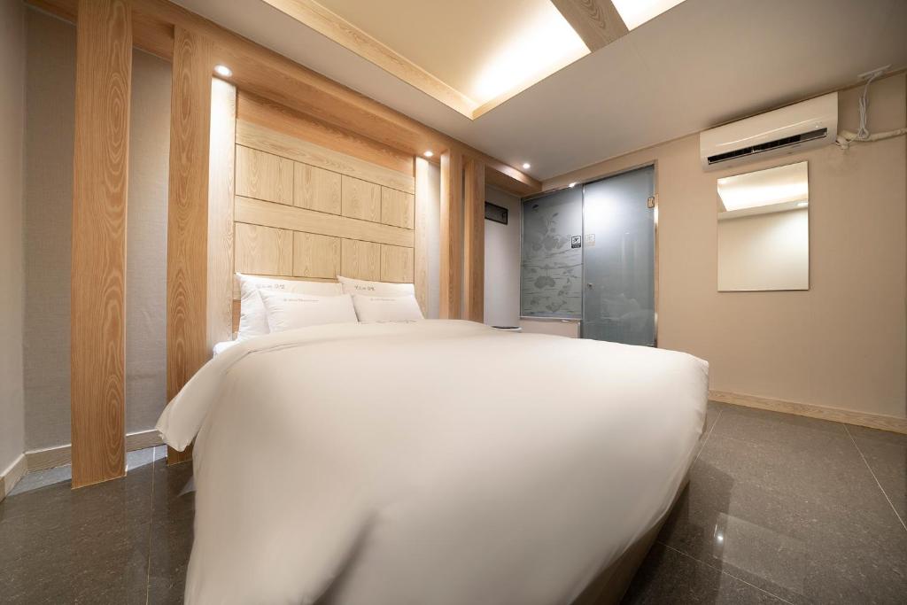Postel nebo postele na pokoji v ubytování Suwon Sunstar Hotel