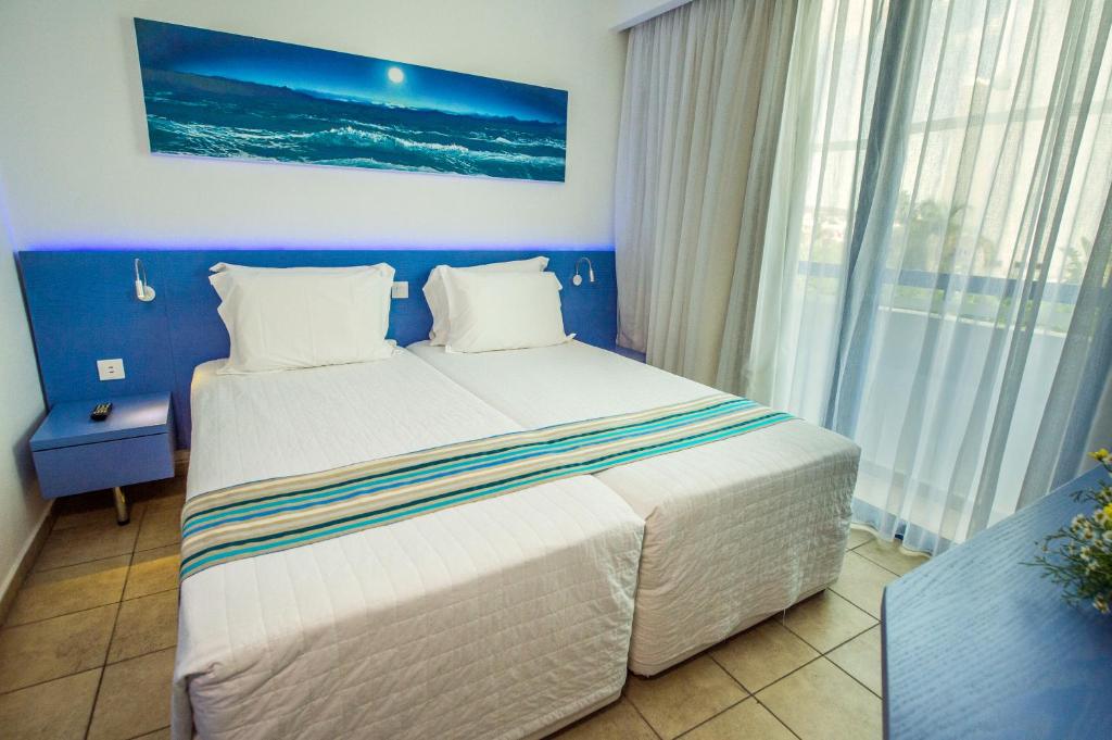 a bedroom with a large bed with a blue wall at Anonymous Beach Hotel (Adults 16+) in Ayia Napa
