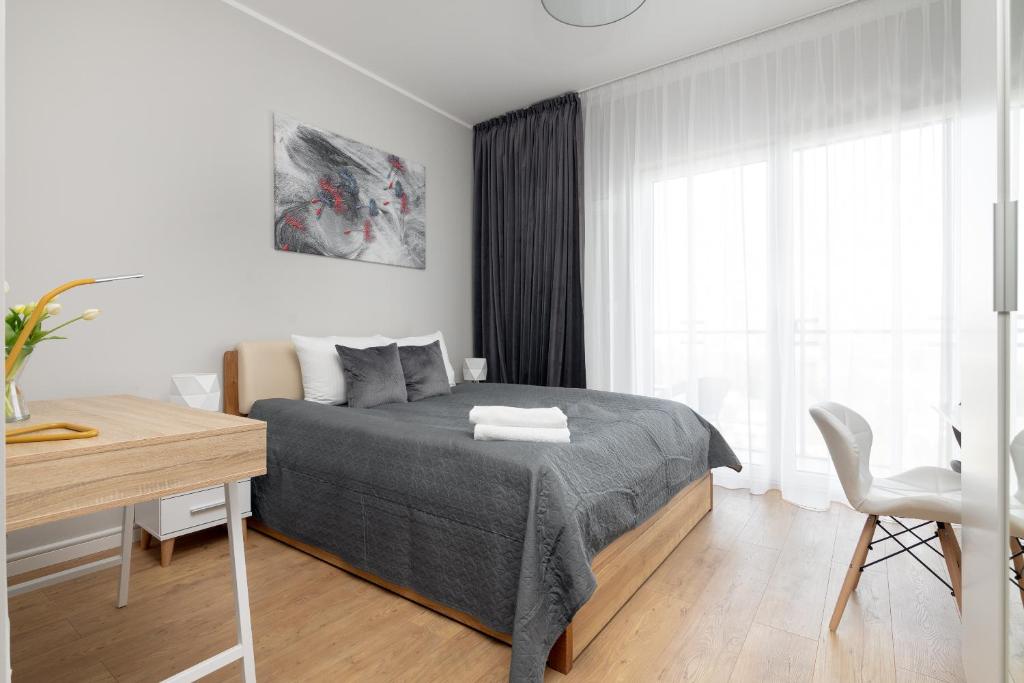 a white bedroom with a bed and a desk at Wola Chic Silver Studio in Warsaw