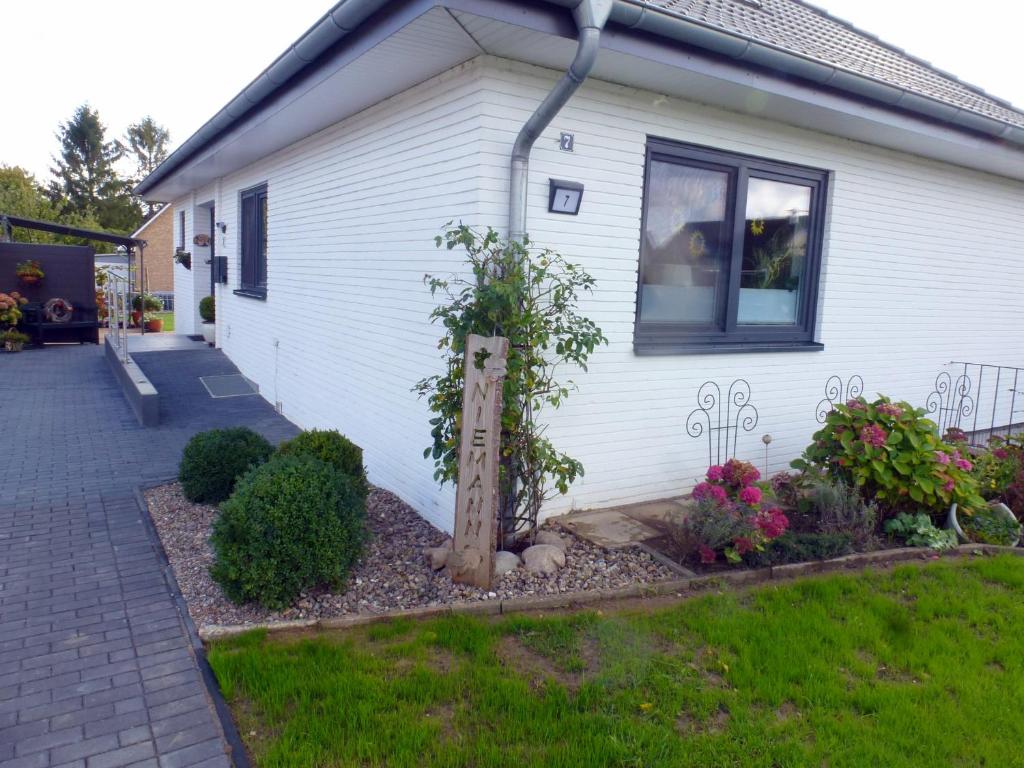 a house with a garden in front of it at Ferienwohnung Am Runenstein 7 in Busdorf