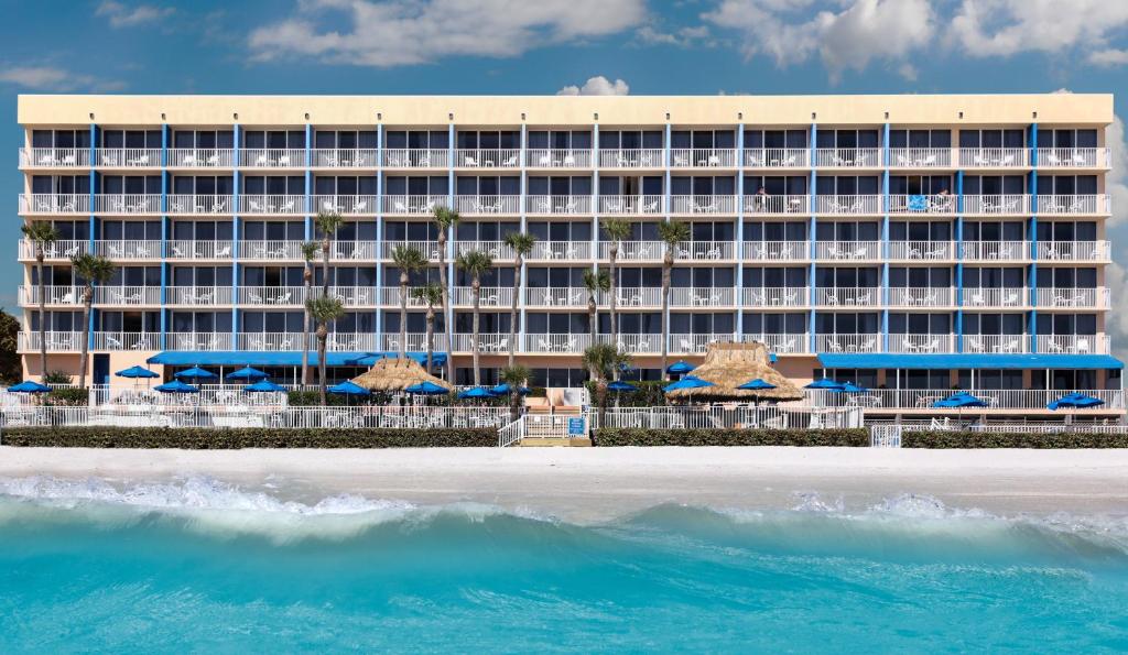 a beach scene with a large building and ocean at DoubleTree Beach Resort by Hilton Tampa Bay – North Redington Beach in St. Pete Beach