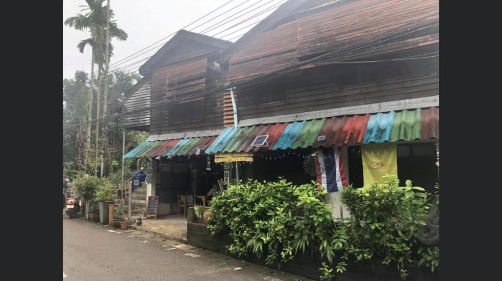 a building with colorful umbrellas on the side of it at Pano Solar Guest House (พาโน โซล่า เกสเฮ้าส์ ) in Trat