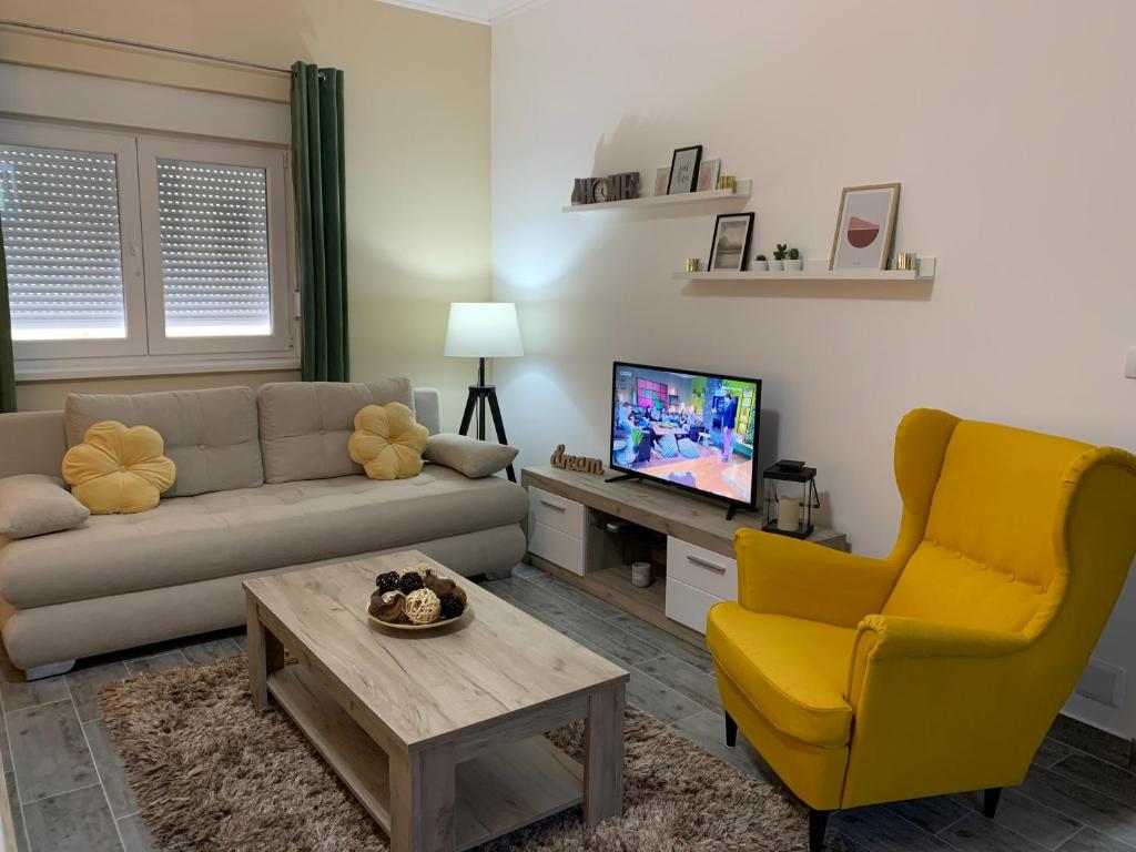 a living room with a couch and a chair and a television at Apartman Hana in Sombor