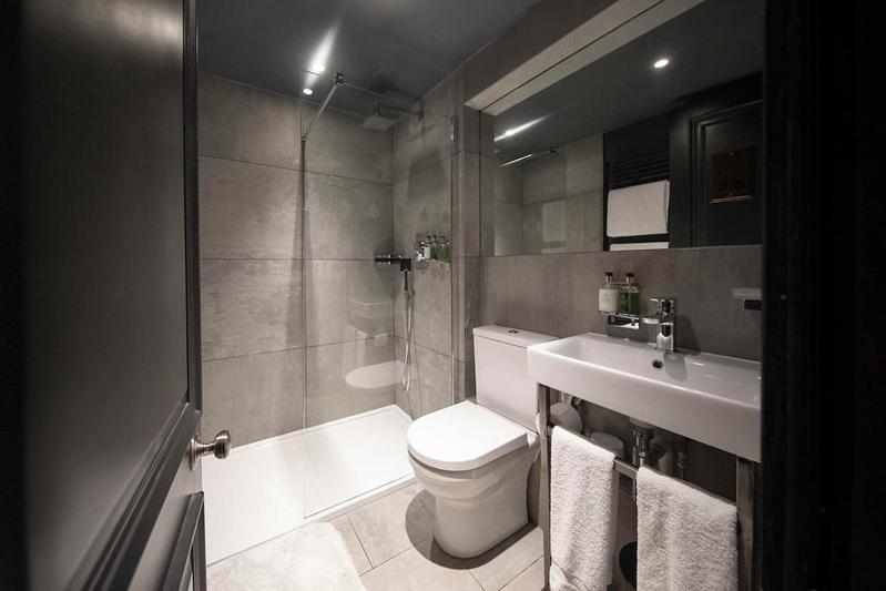 a bathroom with a toilet and a shower and a sink at The Bells - Luxury Serviced Apartments in Leeds