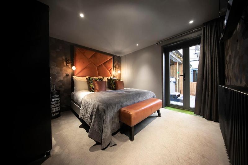 a bedroom with a bed and a large window at The Bells - Luxury Serviced Apartments in Leeds
