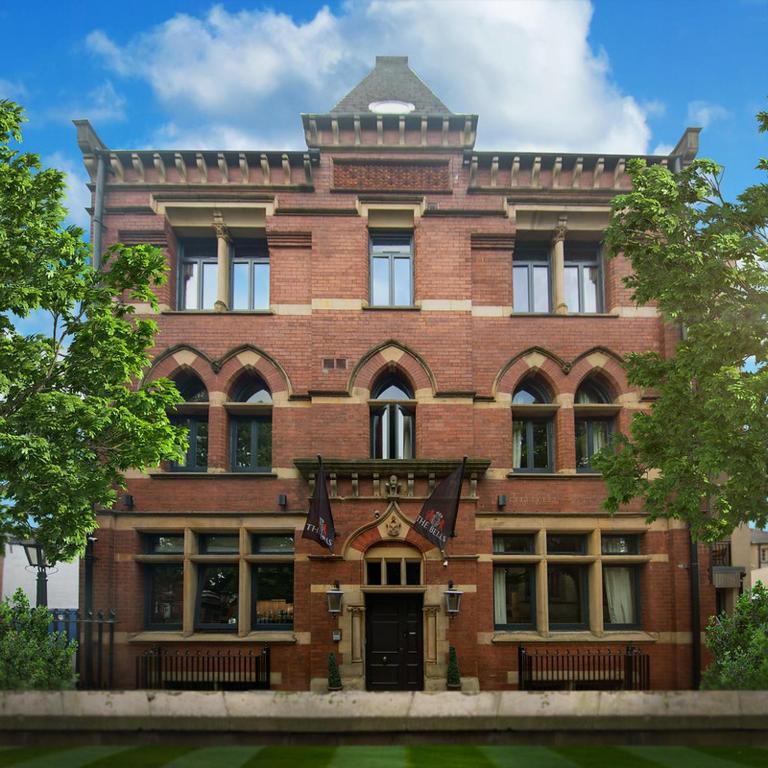 a brick building with a flag in front of it at The Bells - Luxury Serviced Apartments in Leeds
