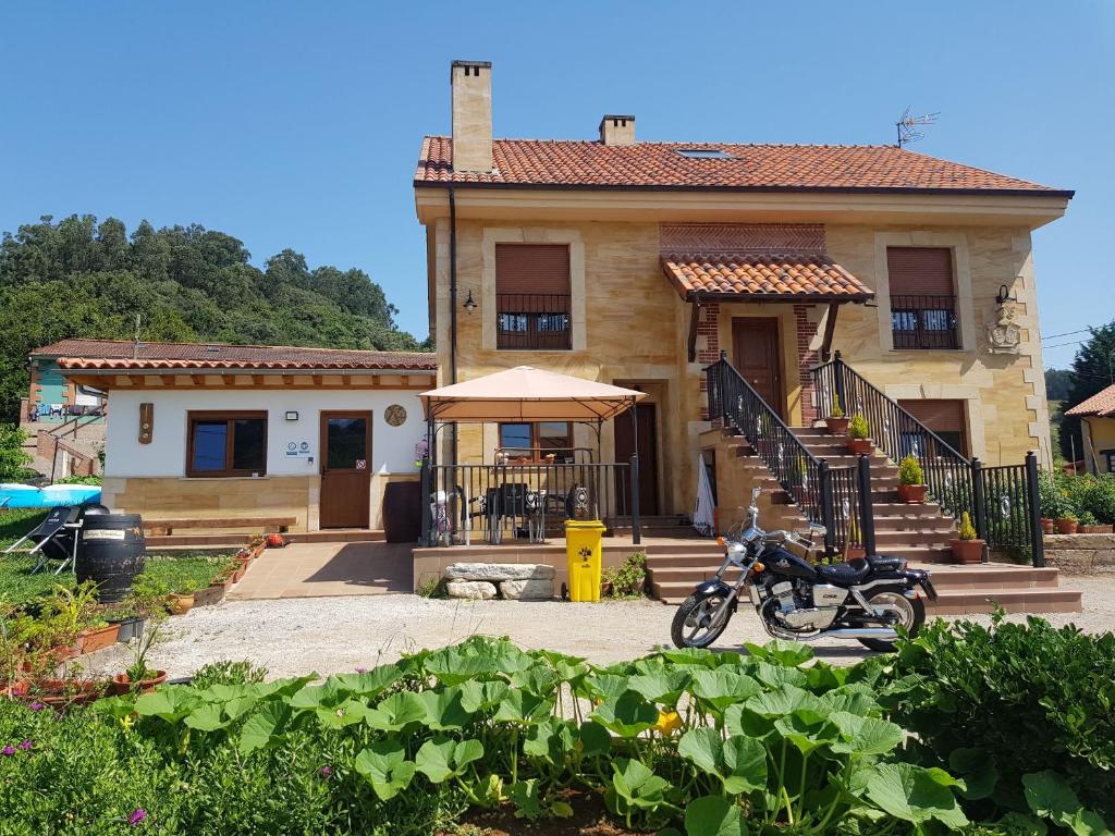 una casa con una motocicleta estacionada frente a ella en La Oliva en Oreña