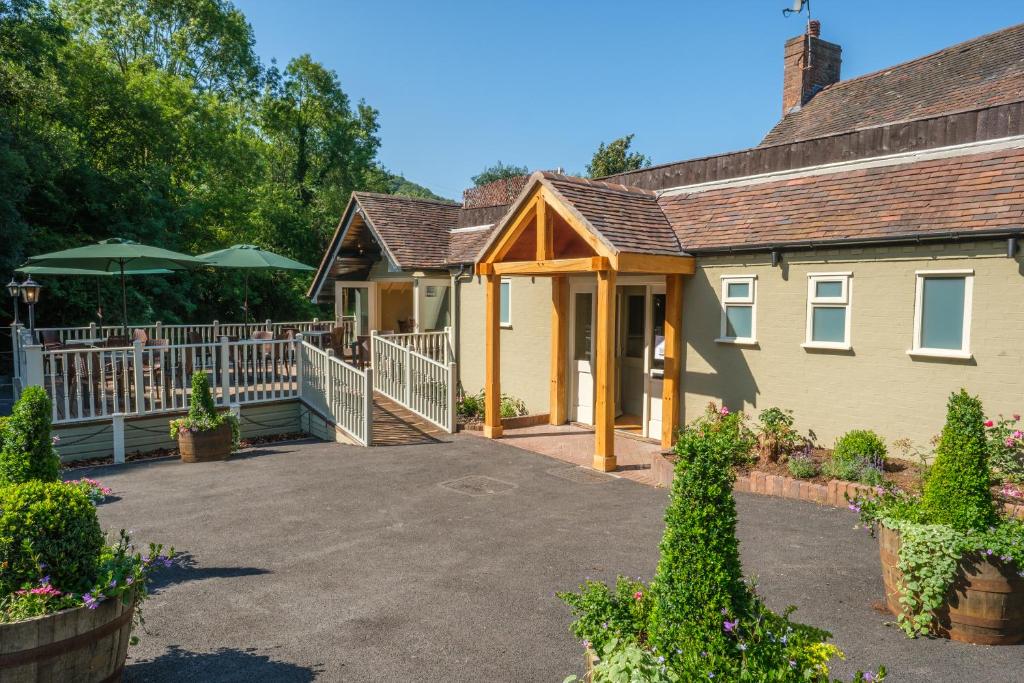 uma casa com uma cerca branca e uma entrada em The Water Rat Ironbridge em Ironbridge