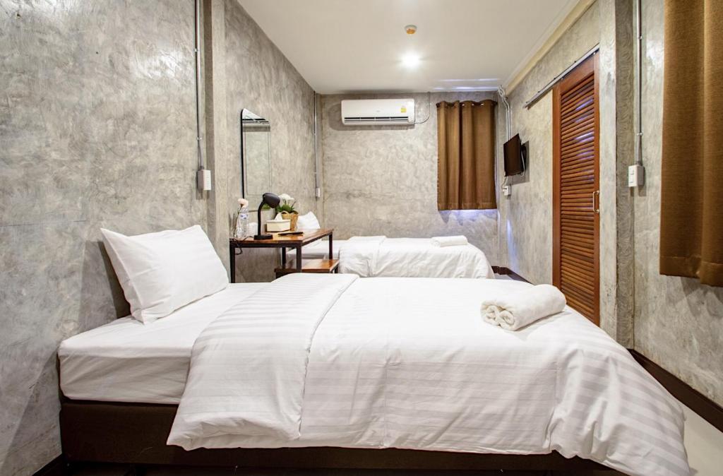 1 dormitorio con 2 camas con sábanas blancas en Momento House en Phra Nakhon Si Ayutthaya