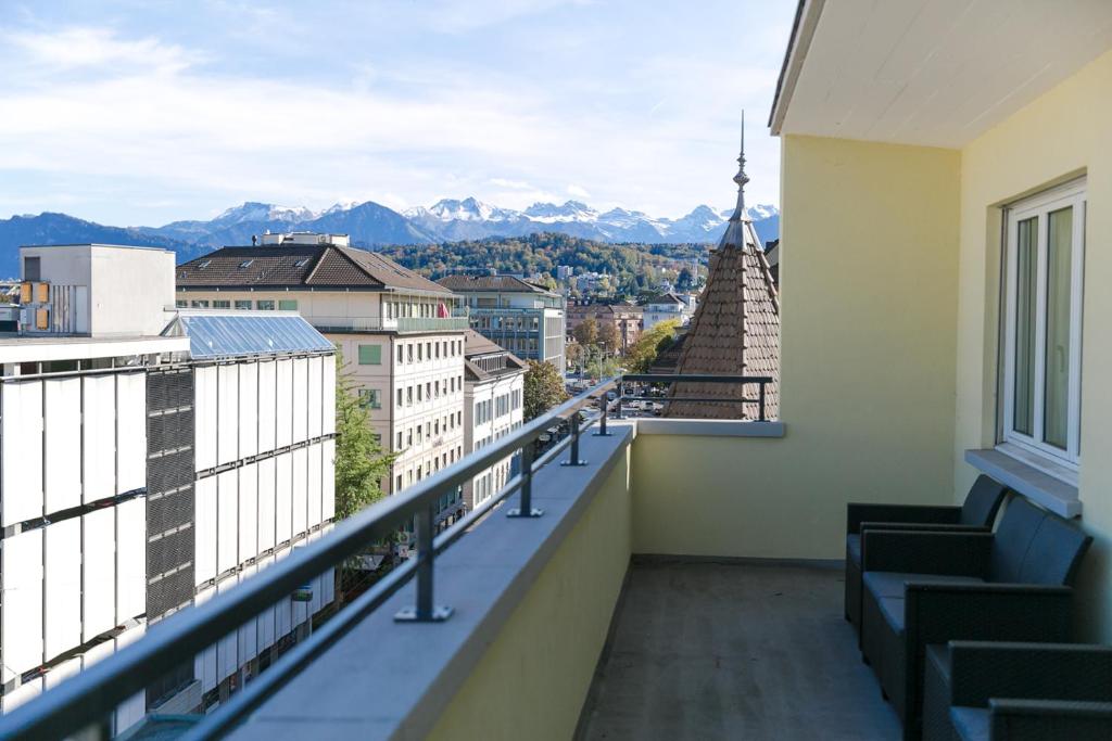 a balcony with a view of a city and mountains at AirHosted - Lucerne City Centre in Lucerne