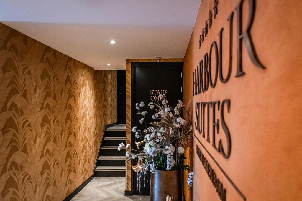 un pasillo con una escalera y una puerta con flores en Harbour Suites Boutique Hotel, en Monnickendam