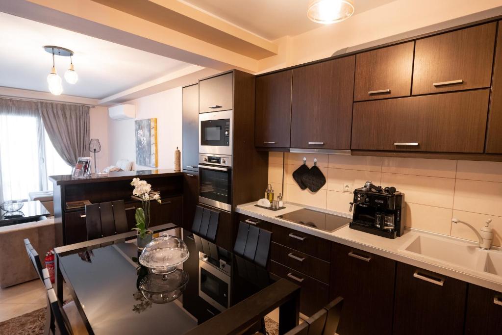 a kitchen with wooden cabinets and a dining table at Meteora 360 Apartment by Meteora Residencies in Kalabaka