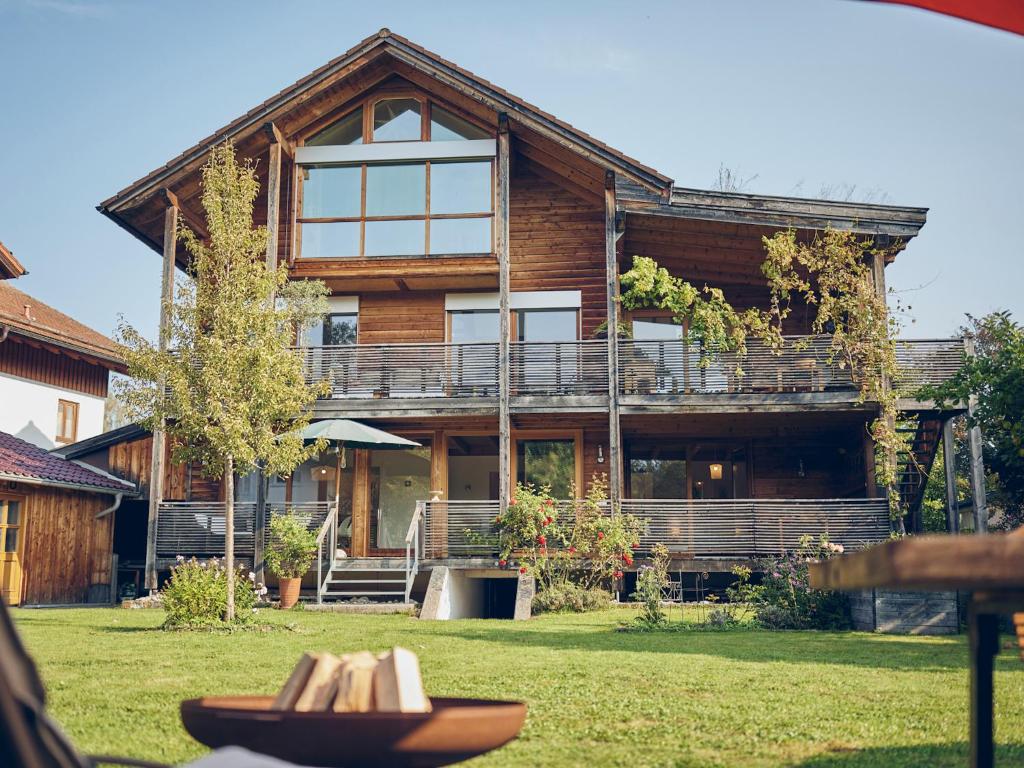 a large wooden house with a large balcony at Naturhaus Luminus in Bad Aibling