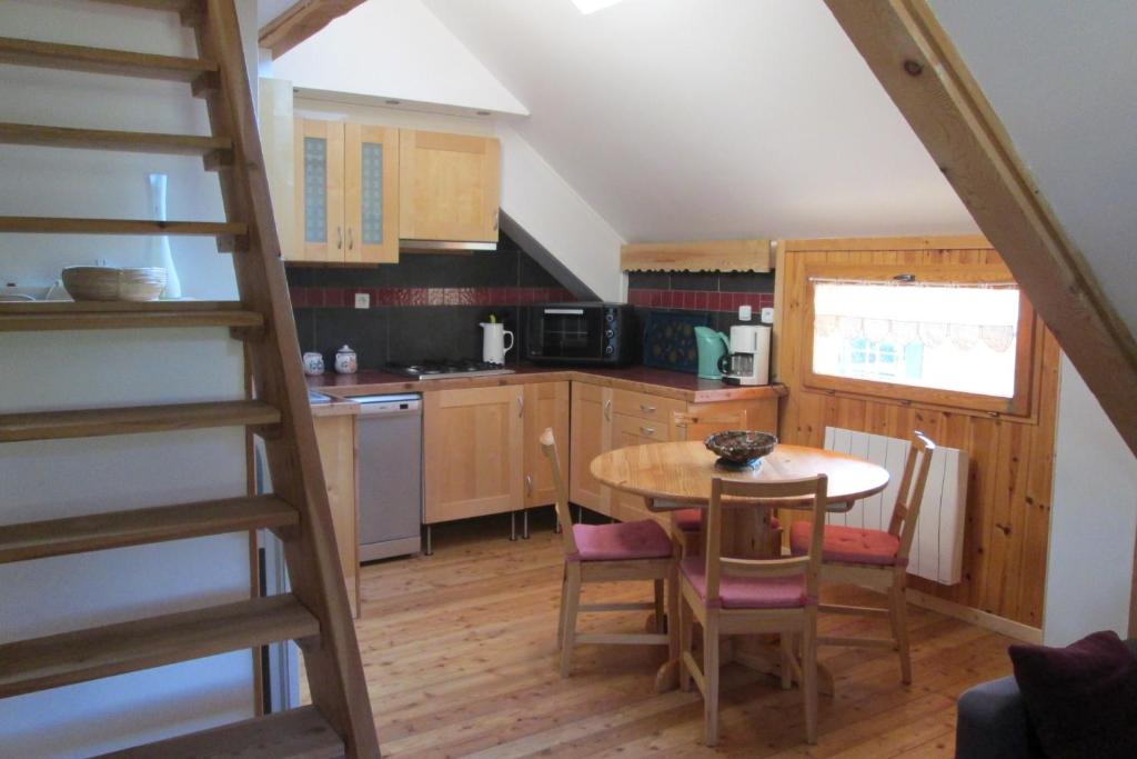 a kitchen with a table and chairs and a staircase at Les Thures Hameau du Roubion Hautes Alpes in Névache