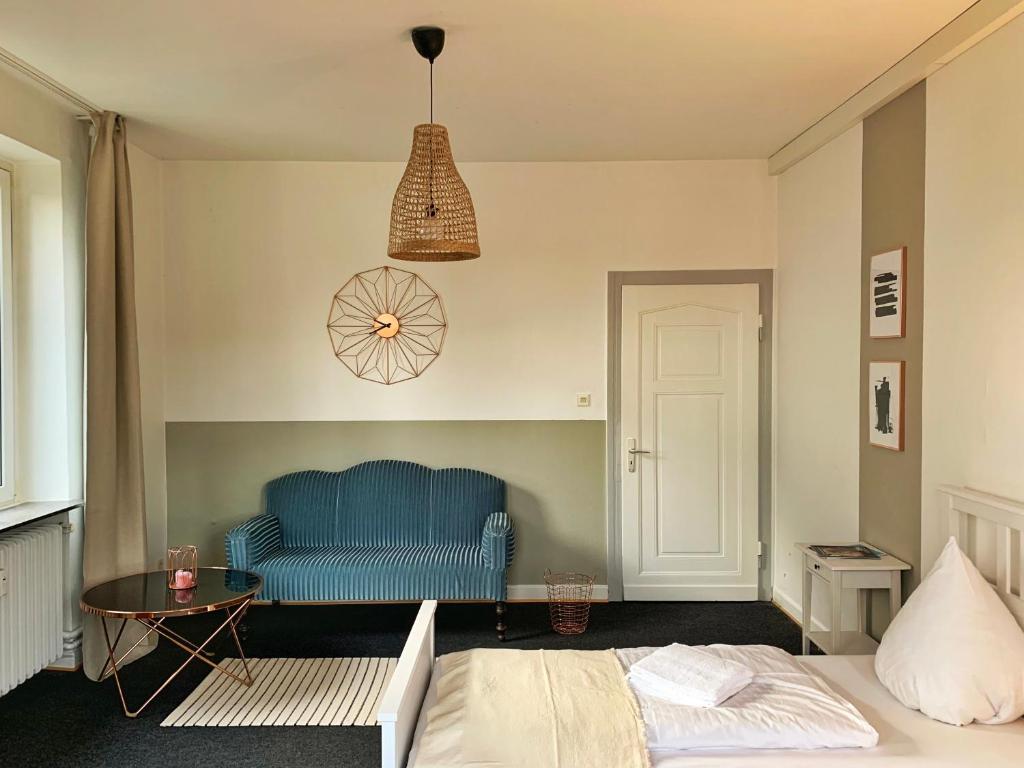 ein Schlafzimmer mit einem blauen Sofa und einem Tisch in der Unterkunft Ferienwohnung Stadtvilla in Bad Marienberg