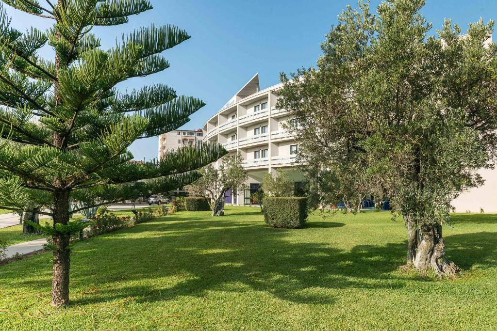 a park with trees in front of a building at Rada Siri in Montepaone