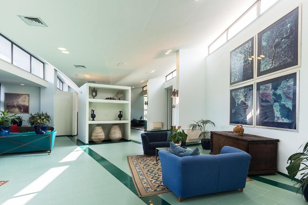 a living room with blue chairs and plants at Rada Siri in Montepaone