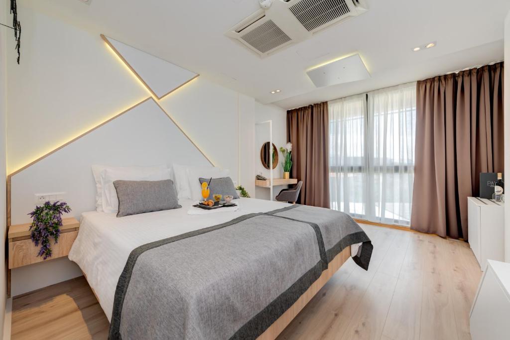 a bedroom with a large bed and a large window at Hotel Pax in Split