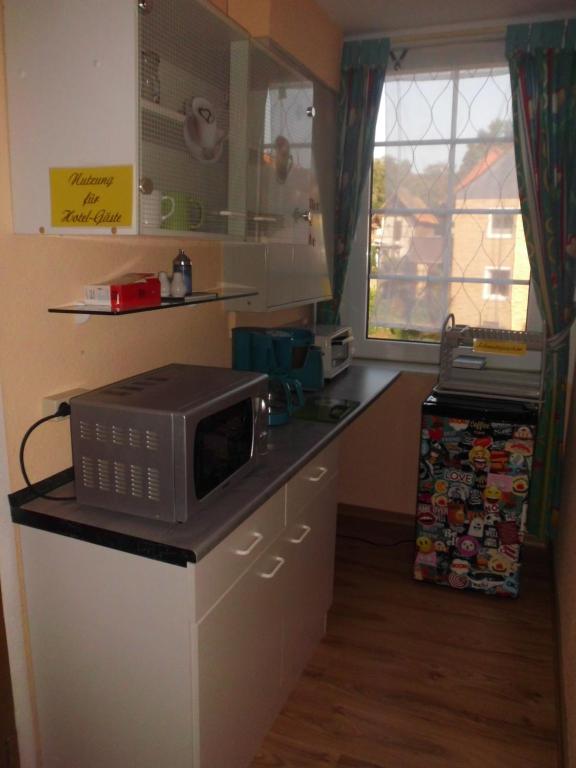 a microwave sitting on top of a counter in a kitchen at Wilhelm Busch Stube in Ebergötzen