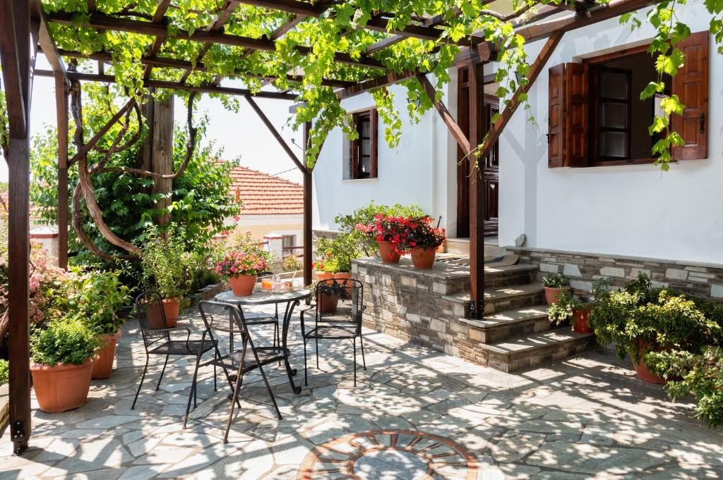 a patio with a table and chairs under a pergola at Elatos Country House in Portaria