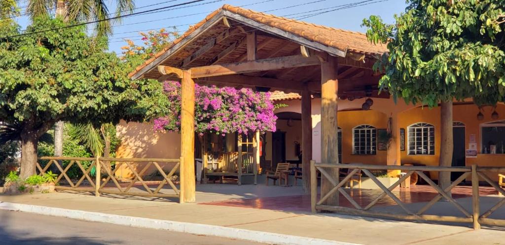 a building with a porch with flowers on it at Pantanal Hotel in Miranda