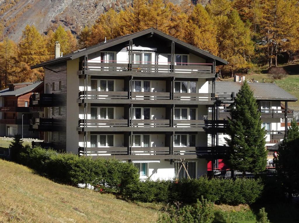 un gran edificio de apartamentos al lado de una colina en Apartments Albana, en Saas-Fee