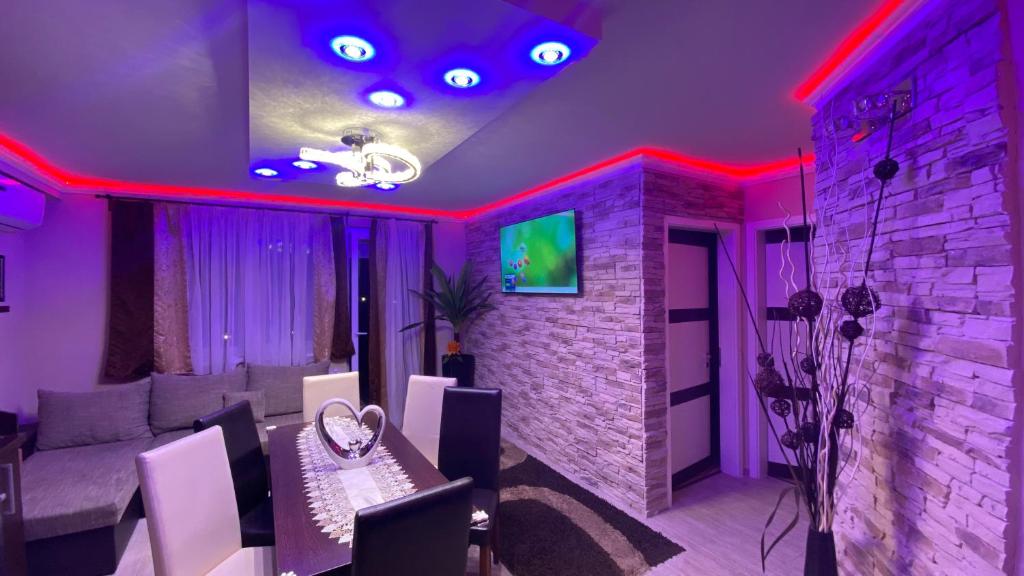 シオーフォクにあるBálint & Timi wellness apartmanの紫と赤の照明が付くダイニングルーム