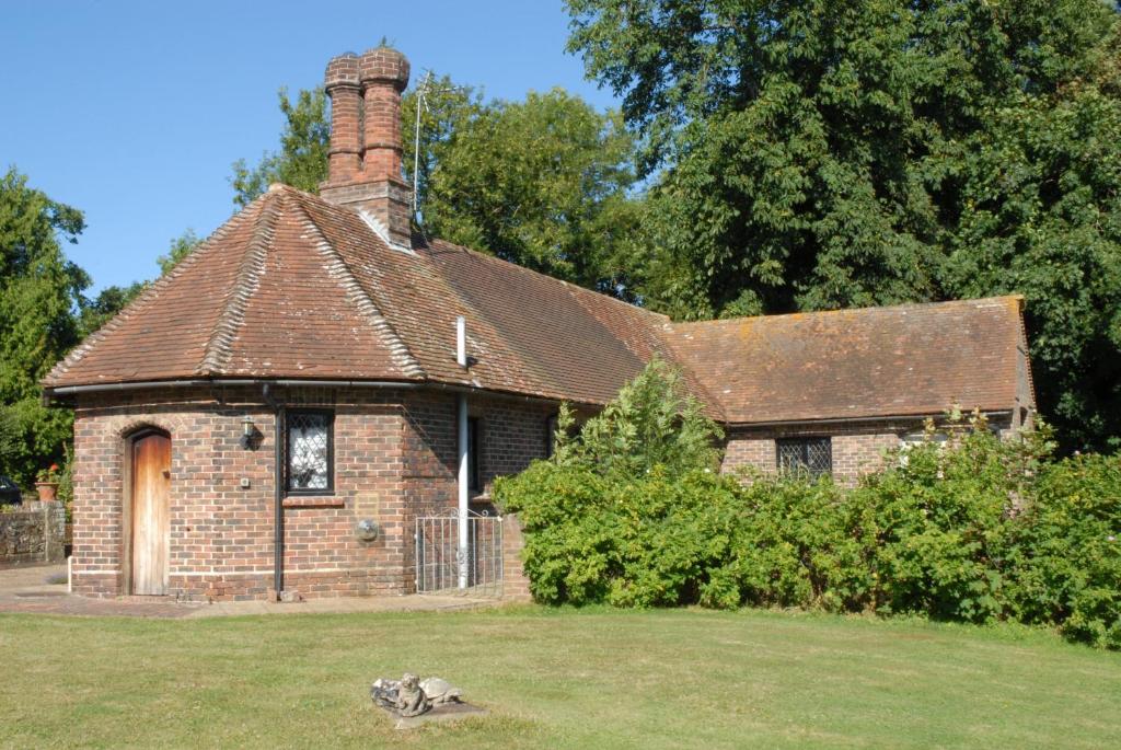 una vieja casa de ladrillo con una chimenea en un patio en Pekes Tudor View en Hailsham