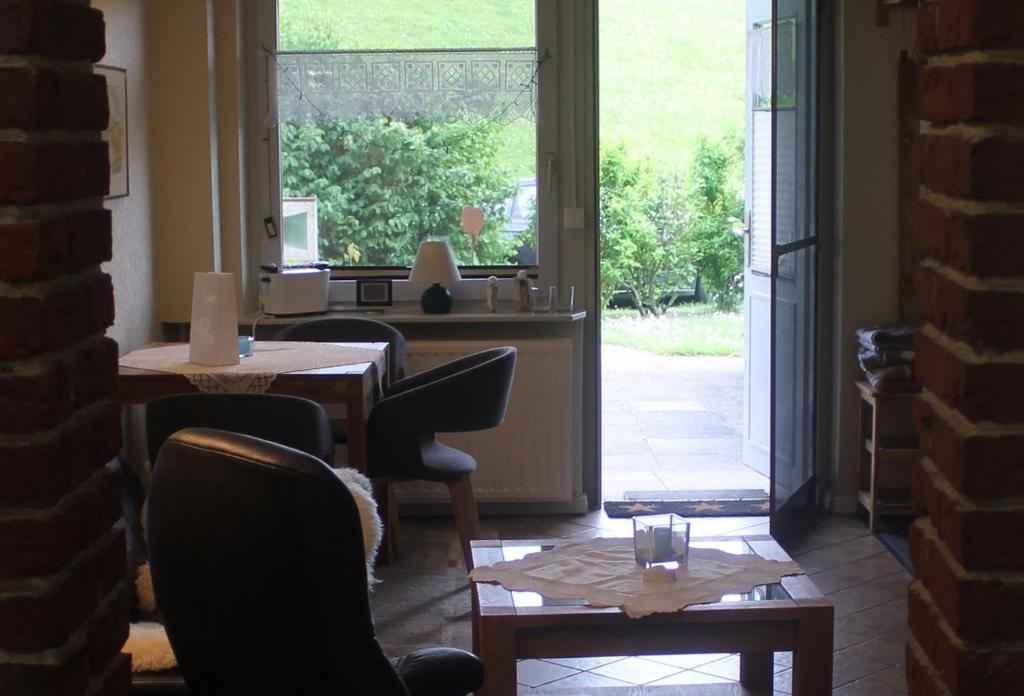 Cette chambre dispose de tables, de chaises et d'une grande fenêtre. dans l'établissement Deichblick Süderhafen, à Nordstrand