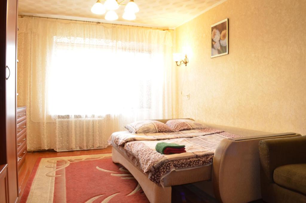 a small bedroom with a bed with a window at Квартира на Дарвина in Tver