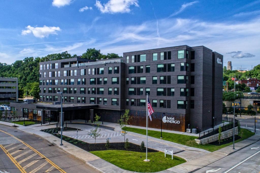 an office building with an american flag in front of it at Hotel Indigo Pittsburgh University - Oakland by IHG in Pittsburgh