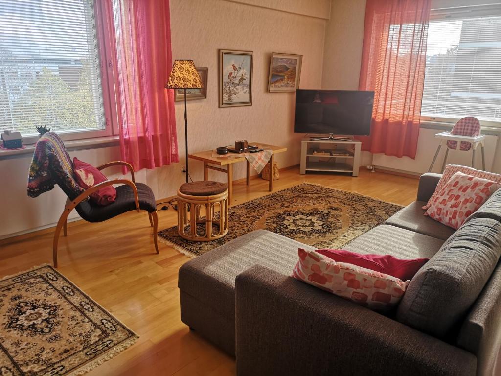 ein Wohnzimmer mit einem Sofa und einem Flachbild-TV in der Unterkunft Apartment Vuorikatu 35 Mummola in Kuopio