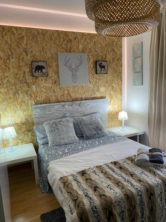 um quarto com uma cama grande e duas mesas em Studio loft con encanto en felechosa em Felechosa