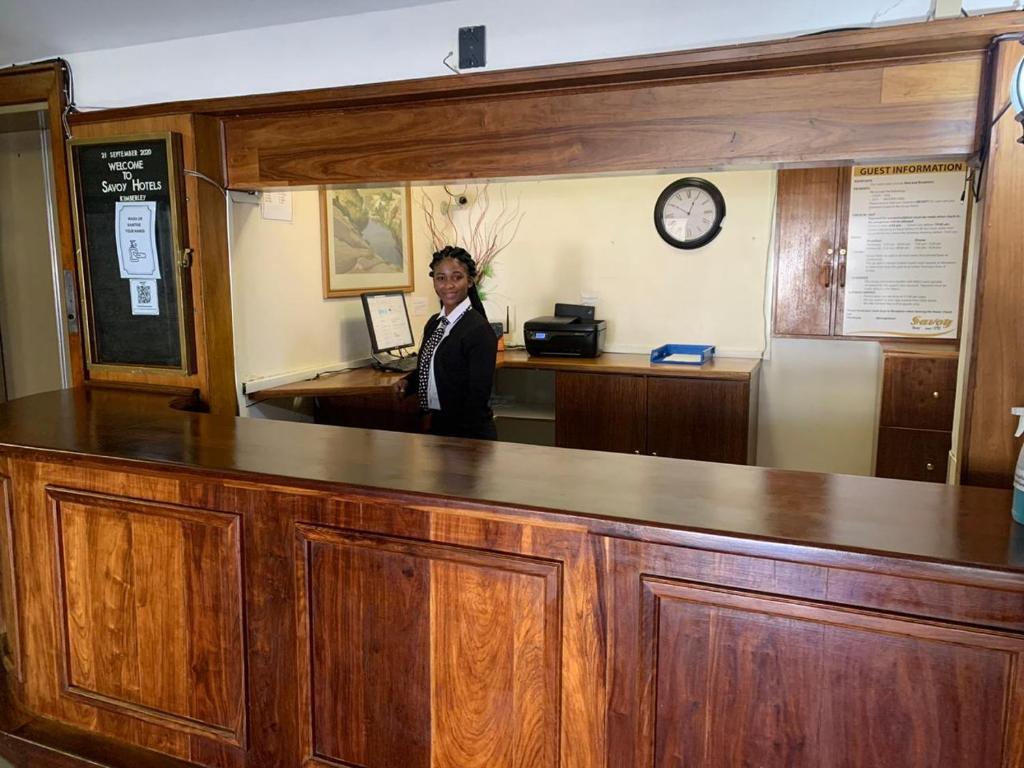 una mujer parada detrás de un mostrador en una oficina en Savoy Hotel Kimberley en Kimberley