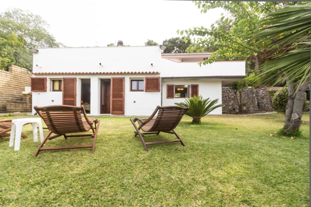 卡波利韋里的住宿－Villa Mara - Goelba，房子院子内的两把椅子