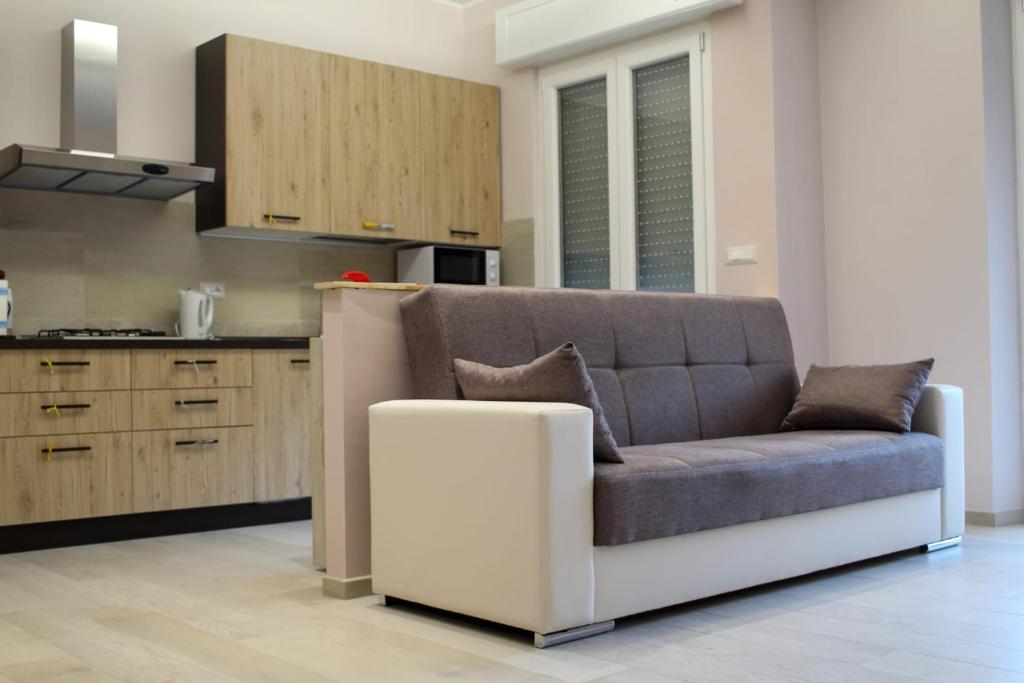 a living room with a couch and a kitchen at Rosy Bed&Breakfast in Terni