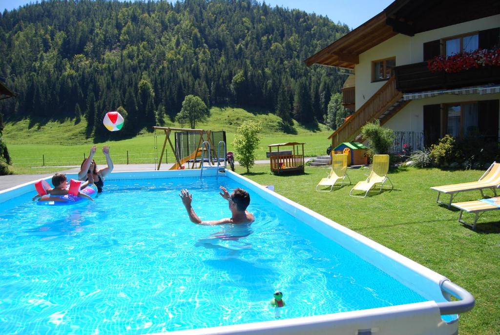 eine Gruppe von Menschen, die in einem Schwimmbad spielen in der Unterkunft Gästehaus Luise in Waidring