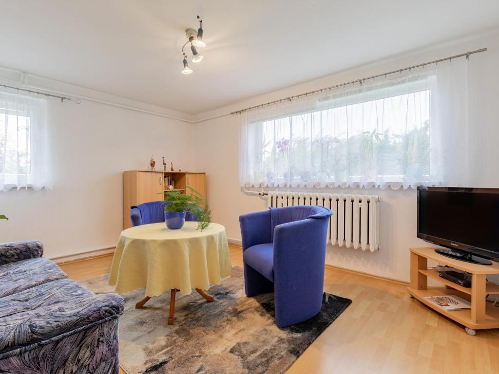 sala de estar con sillas azules y mesa en Pretty Farmhouse with Swimming Pool, Garden, Terrace, BBQ, en Kröpelin