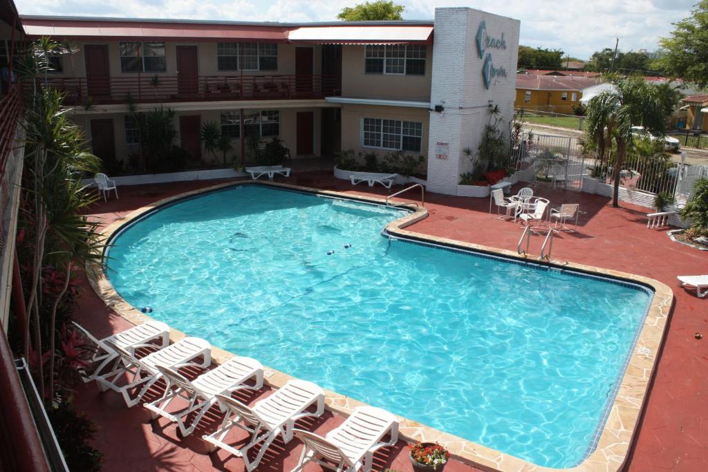 a large swimming pool with chairs and a hotel at Beach and Town Motel in Hollywood