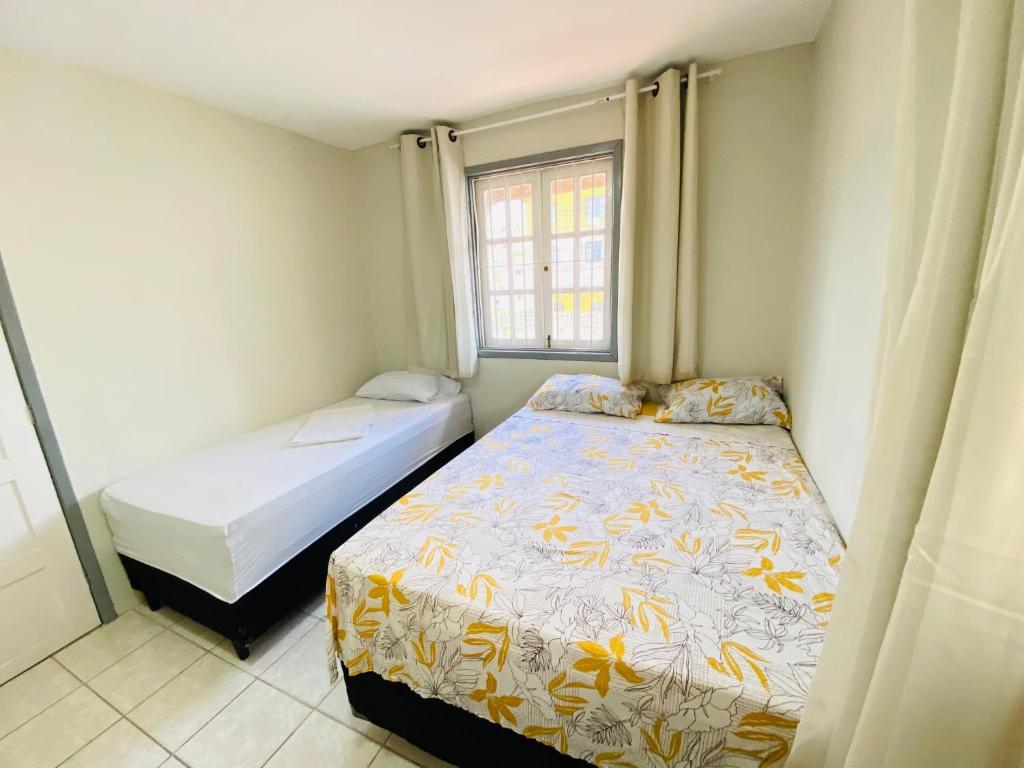 1 dormitorio con 2 camas y ventana en Ô Hostel en Porto De Galinhas