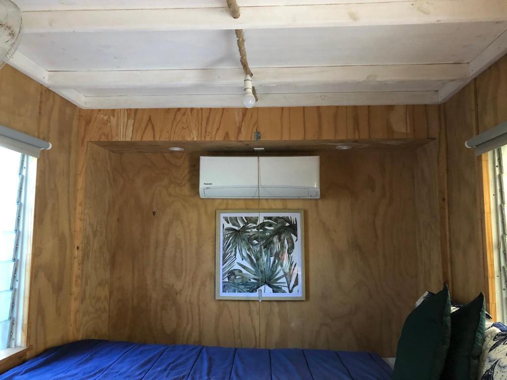 耐莉灣的住宿－SEA-green，卧室配有一张床,墙上挂着一幅画