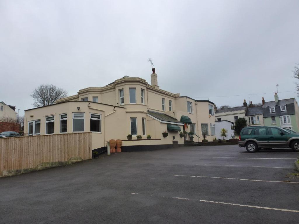 a car parked in a parking lot in front of a house at The Kingswood Guest House - Adult Only in Weymouth